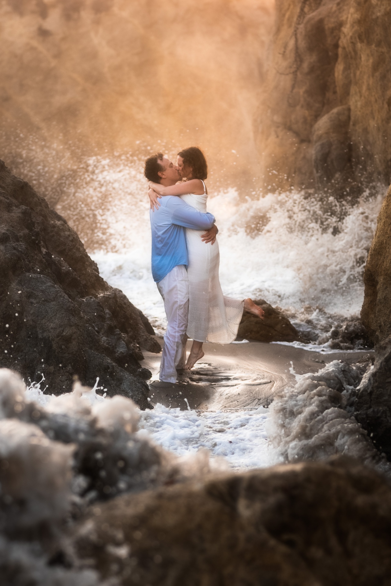 Couple embracing in crashing Malibu waves